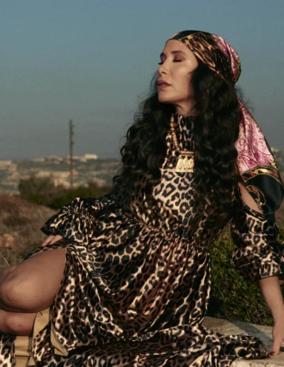 Sabine Fouchaux Lebanese Award-winning Singer & Actress poses in nature in a leopard pattern long dress and a bandana over her head photographed by Jean-Claude Dib