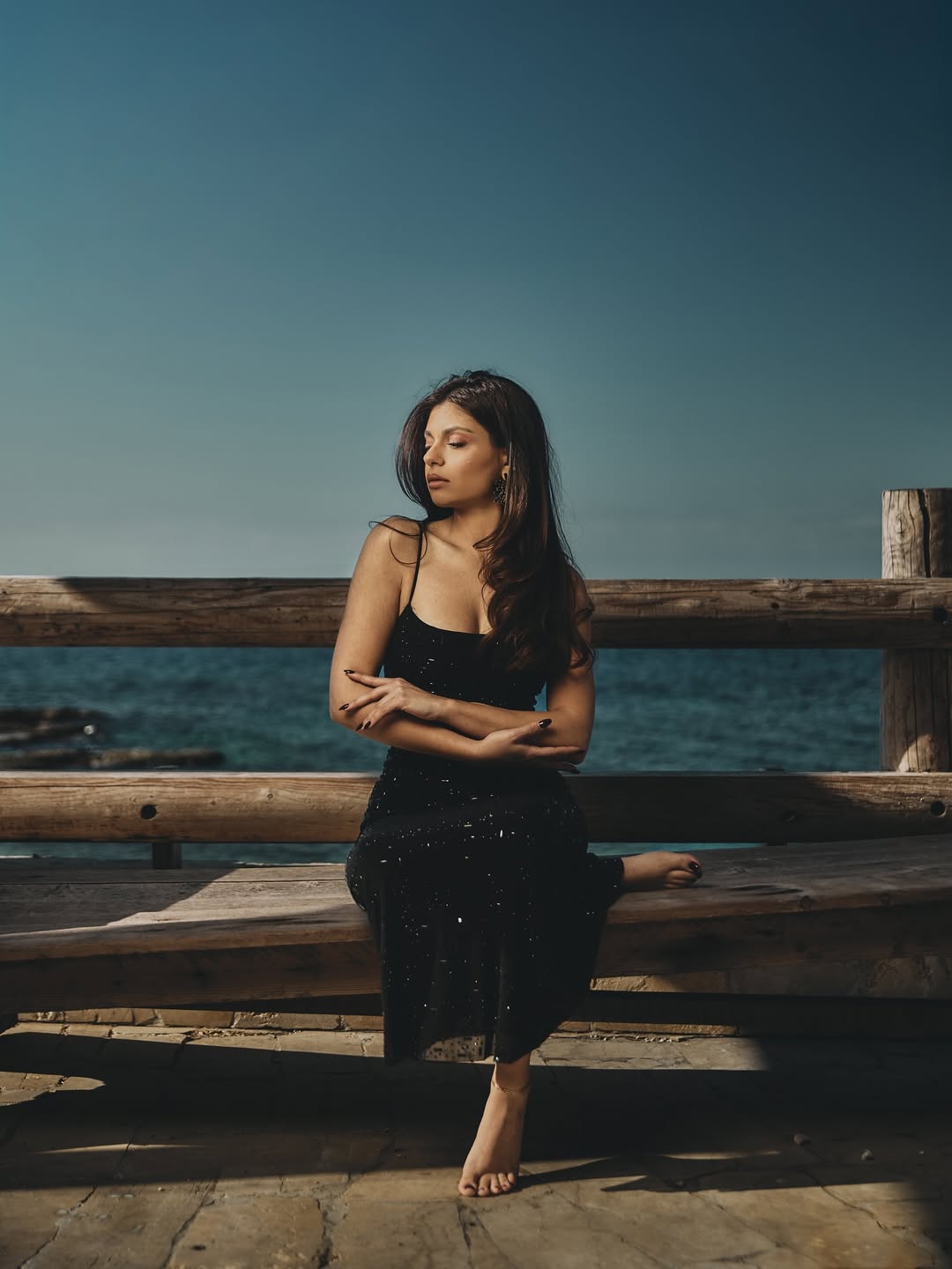 Carol Hannoun relaxes on a wooden bench with her legs elevated, photographed by filmmaker Jean-Claude Dib.